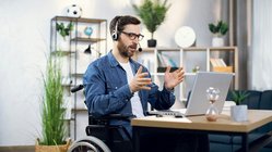 Mann im Rollstuhl am Notebook