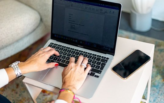 Foto von Laptop, an dem eine Person arbeitet